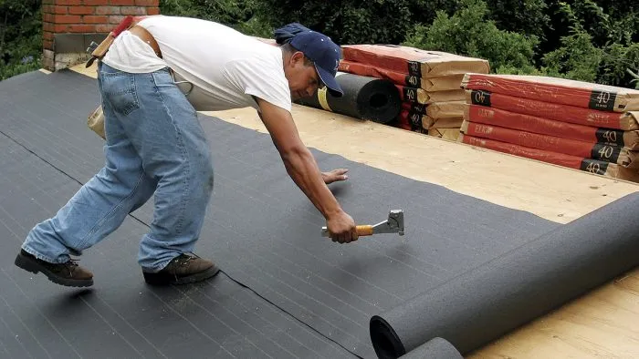 Underlayment being installed on a roof